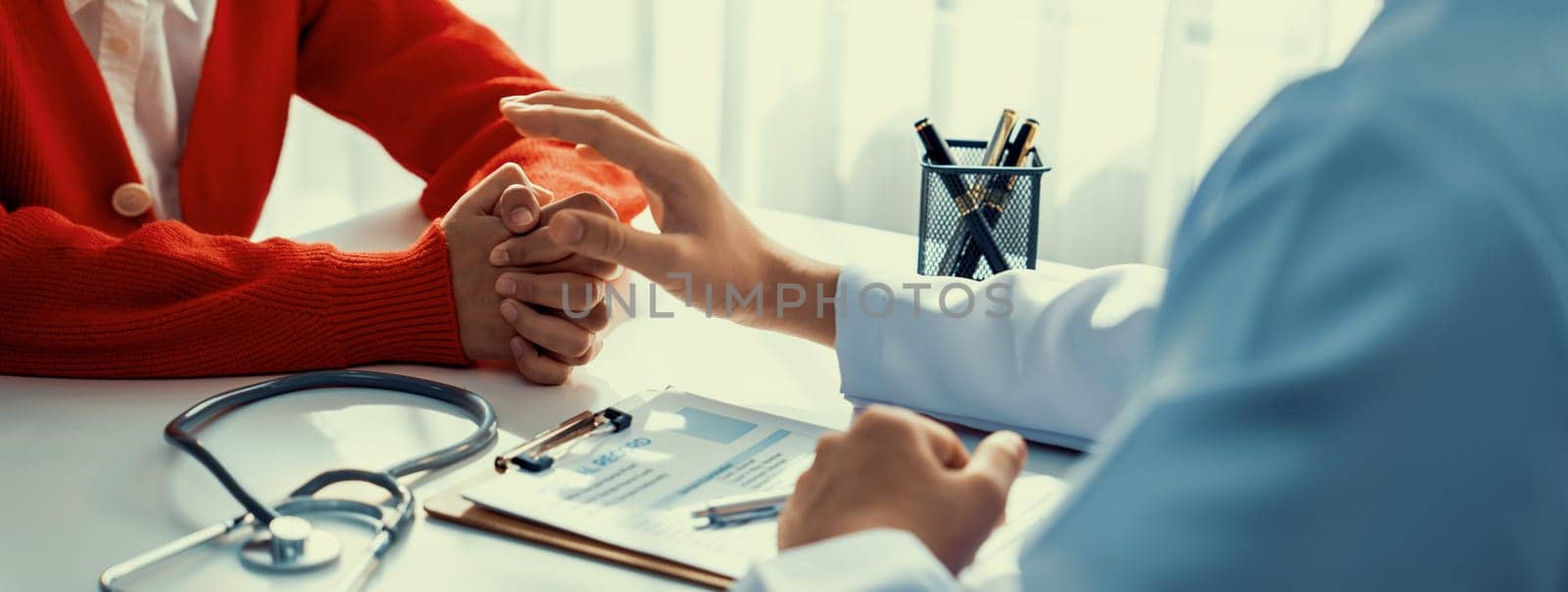 Patient attend doctor's appointment at clinic or hospital office, discussing medical treatment option and explaining diagnostic result while consoling and comforting patient. Panorama Rigid