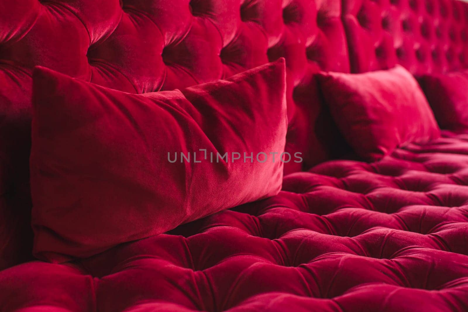 Textured surface of sofa with velour tapestry of red color close-up
