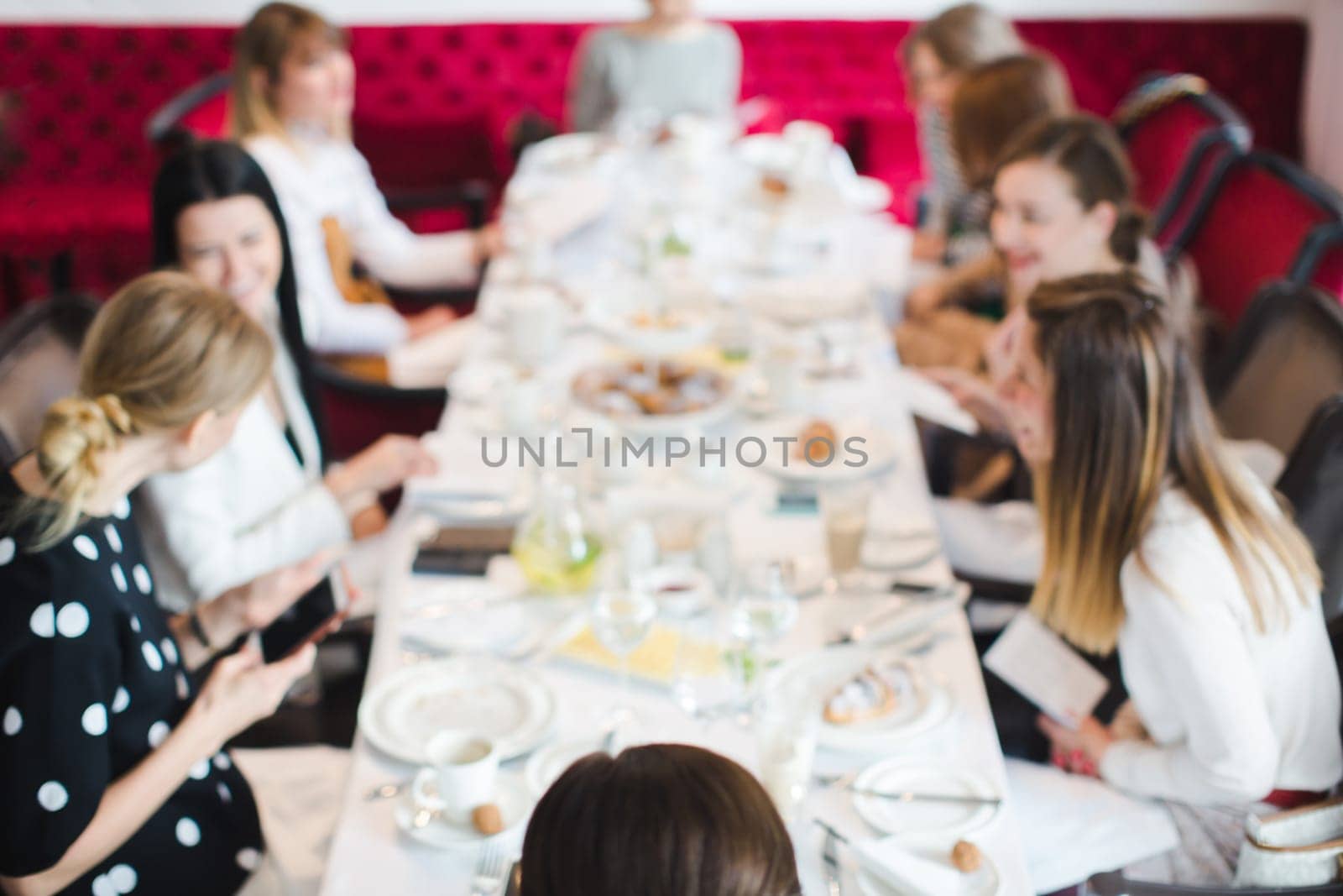 bluer soft focus Women sitting at long table on meeting and communicating. French breakfast, French lesson for adults.