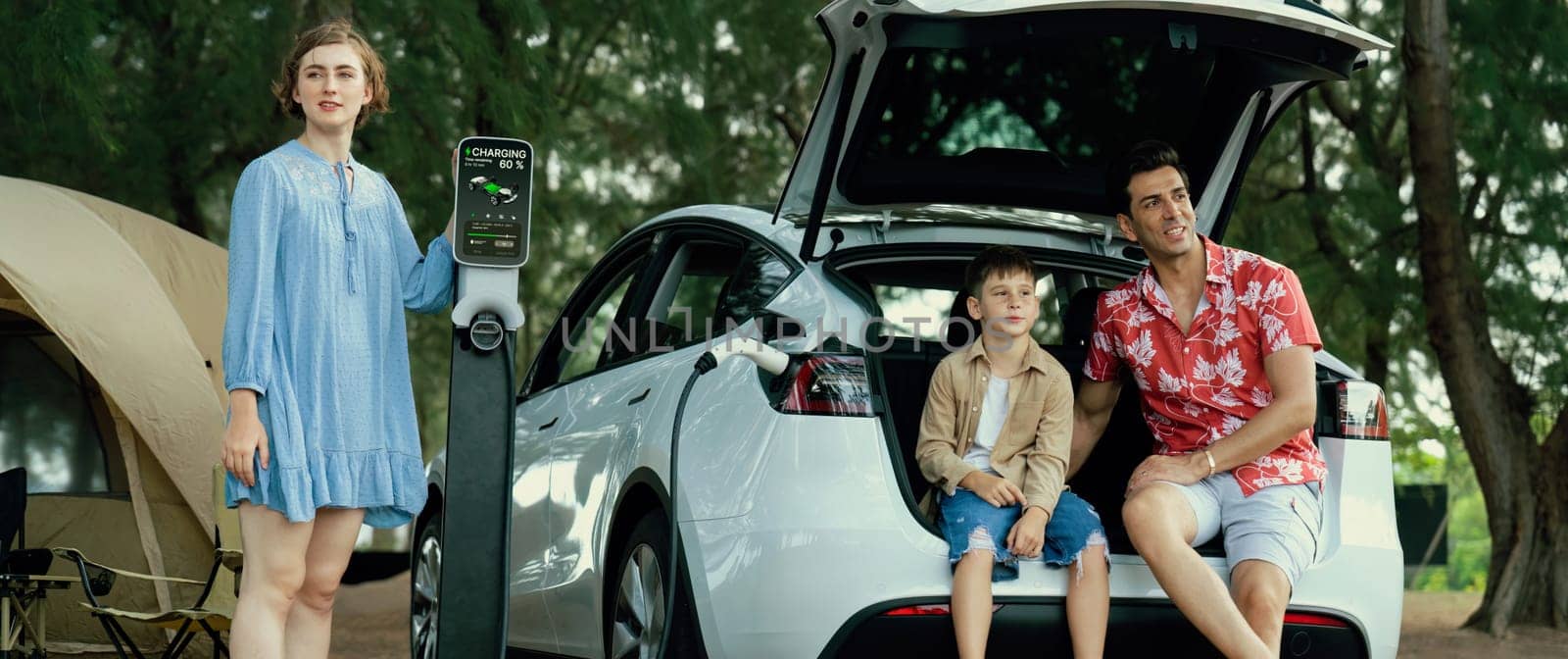 Lovely family recharge EV car with EV charging station in campsite. Perpetual by biancoblue