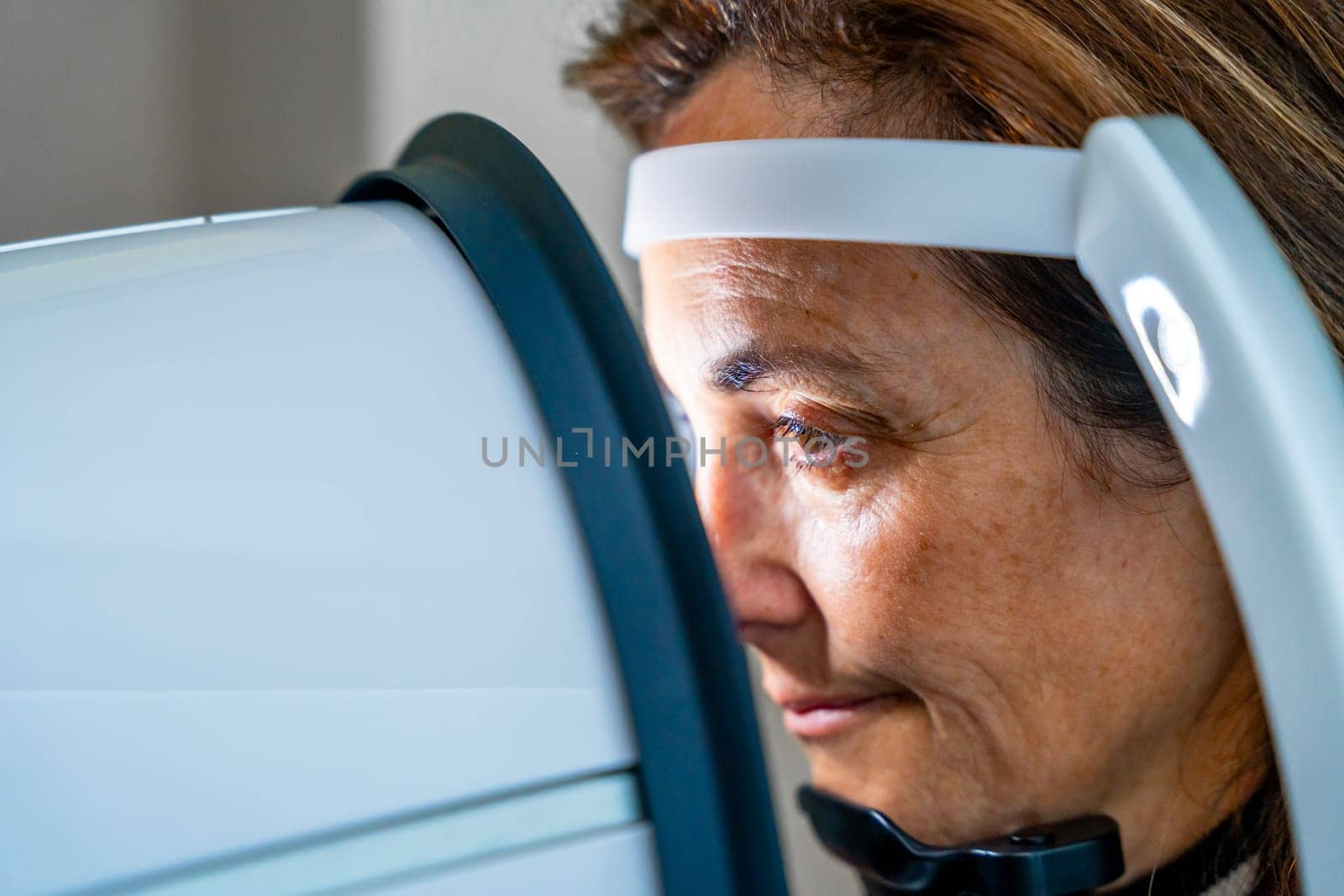 Mature woman receiving an innovative a laser treatment for glaucoma by Huizi