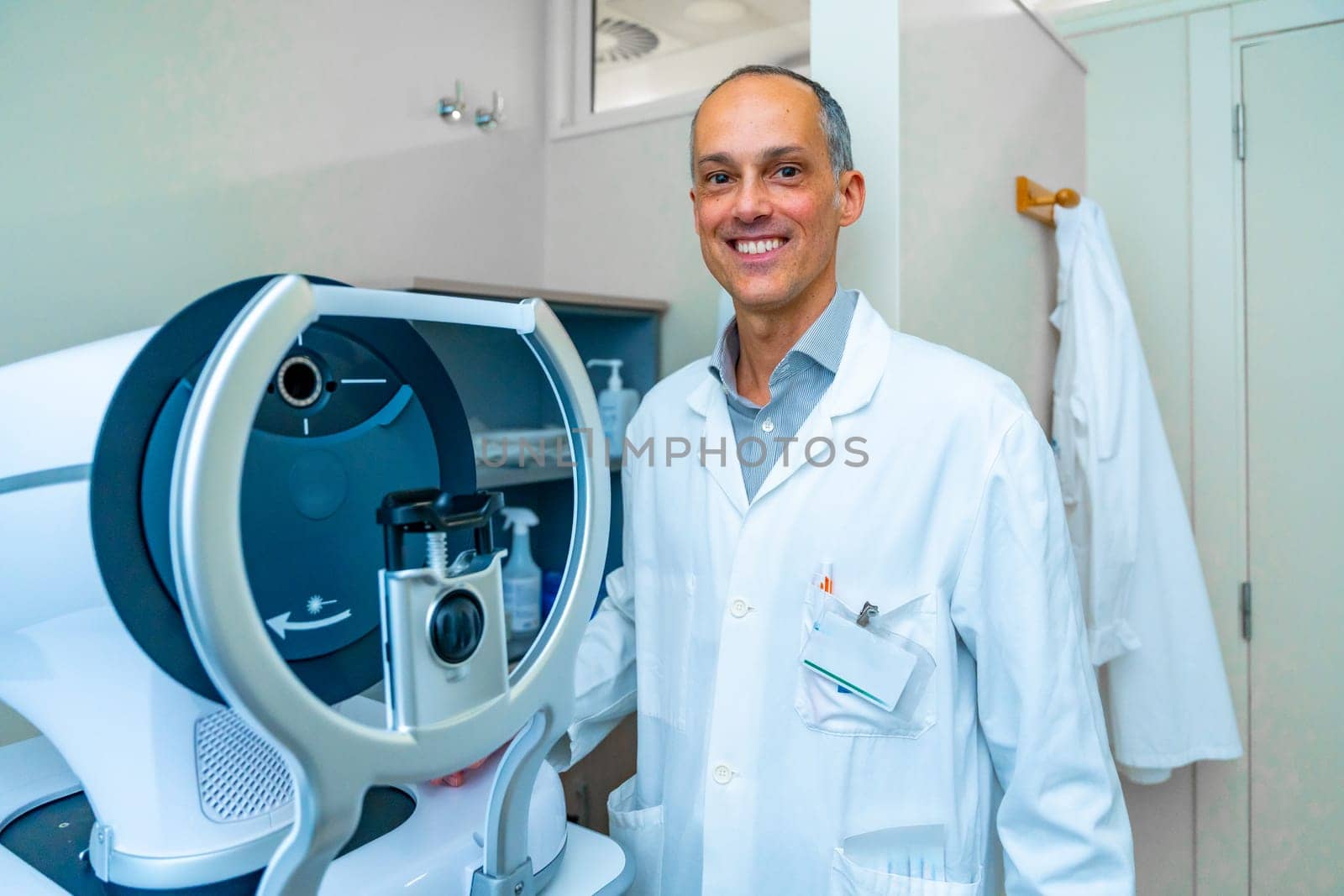 Portrait of an ophthalmologist in an innovative clinic standing next to a laser machine to treat glaucoma