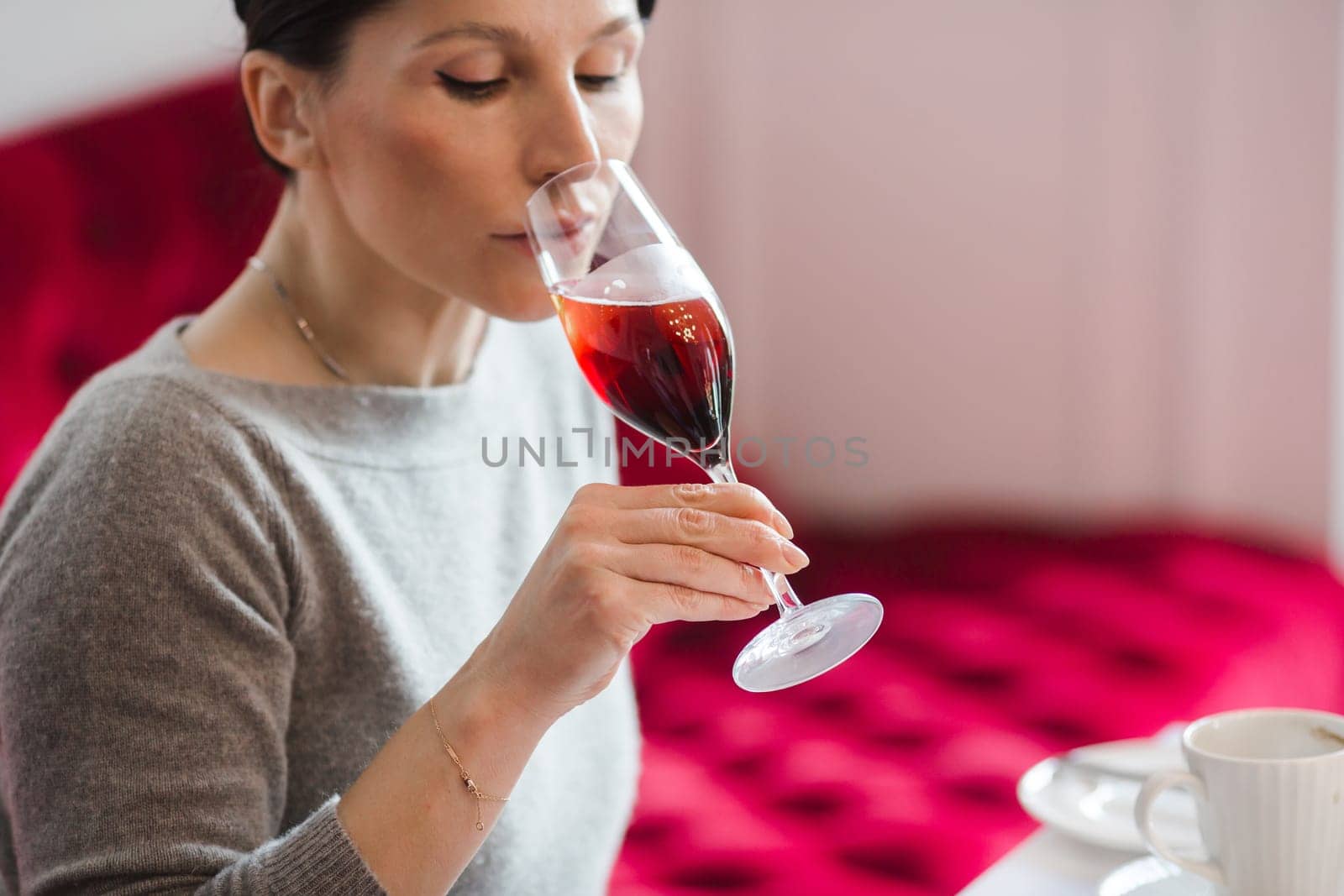 Elegant woman looking away while drinking cocktail in restaurant.