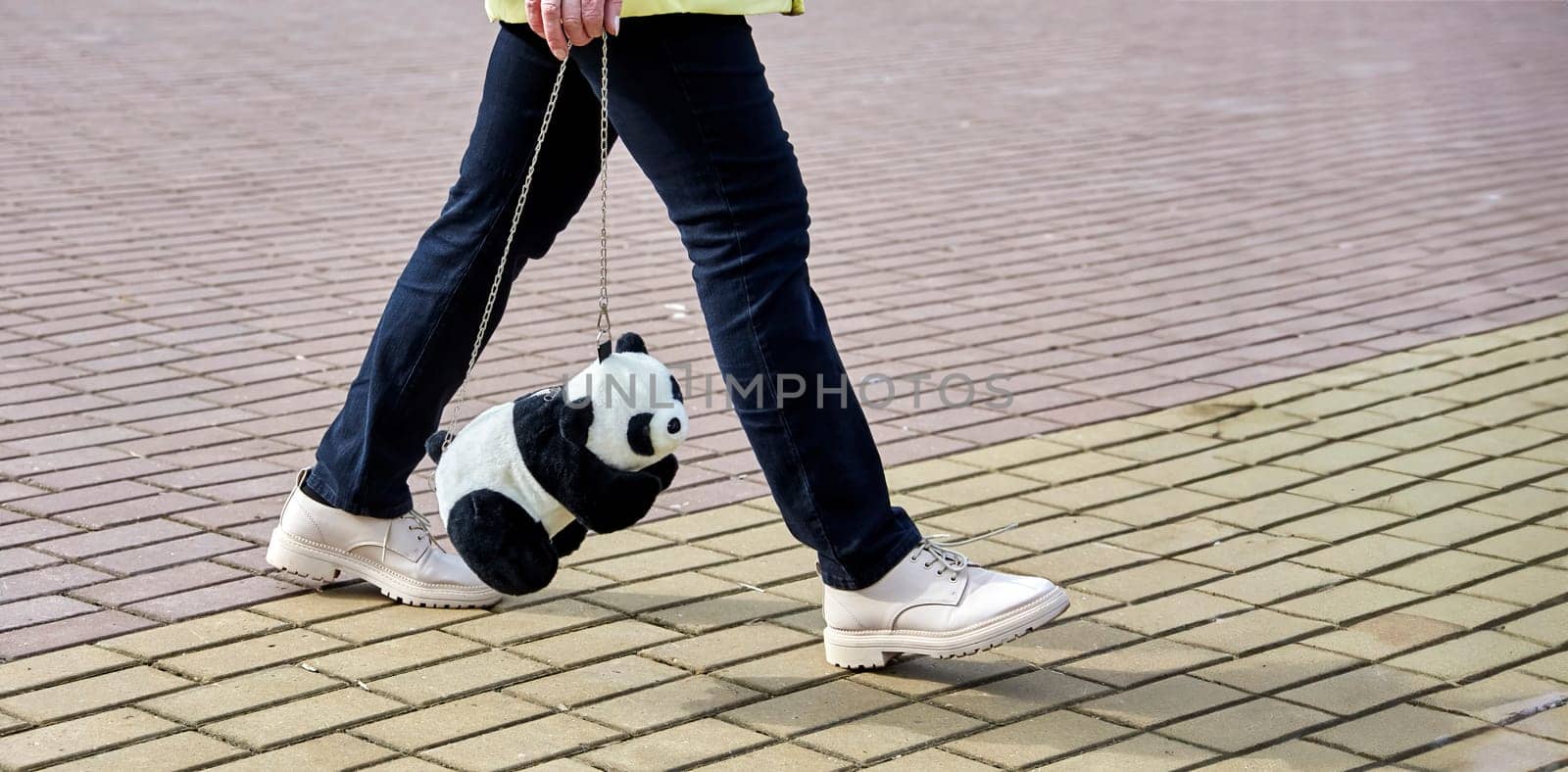 Stylish Woman with Adorable Panda Bag Strutting in Urban Setting, Trendy Street Fashion Scene by Hil