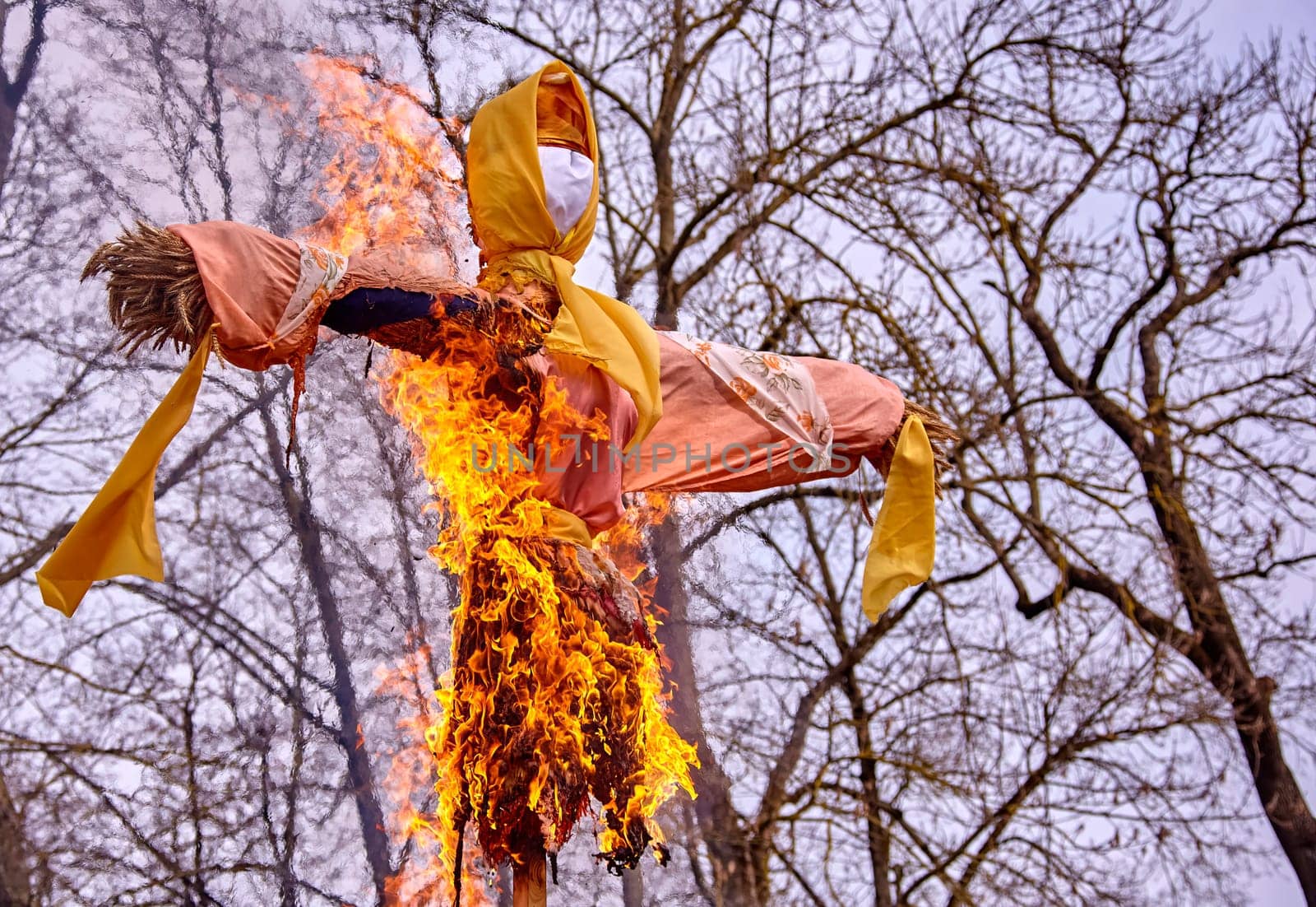 Scarecrow burning symbolizing spring arrival and new beginnings in the countryside with copy space by Hil