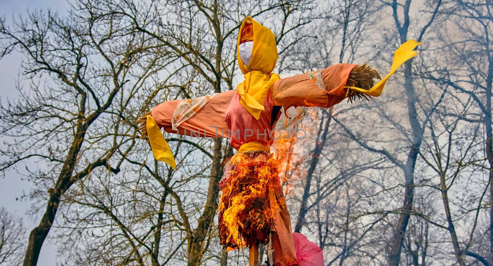 Scarecrow burning symbolizing spring arrival and new beginnings in the countryside with copy space by Hil