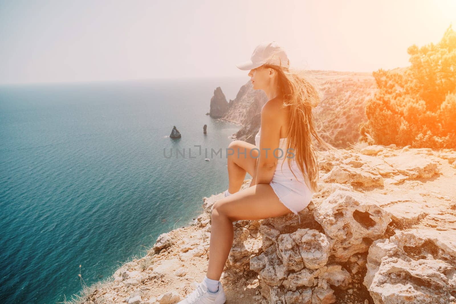 Woman summer travel sea. Happy tourist enjoy taking picture outdoors for memories. Woman traveler posing over sea bay surrounded by volcanic mountains, sharing travel adventure journey by panophotograph