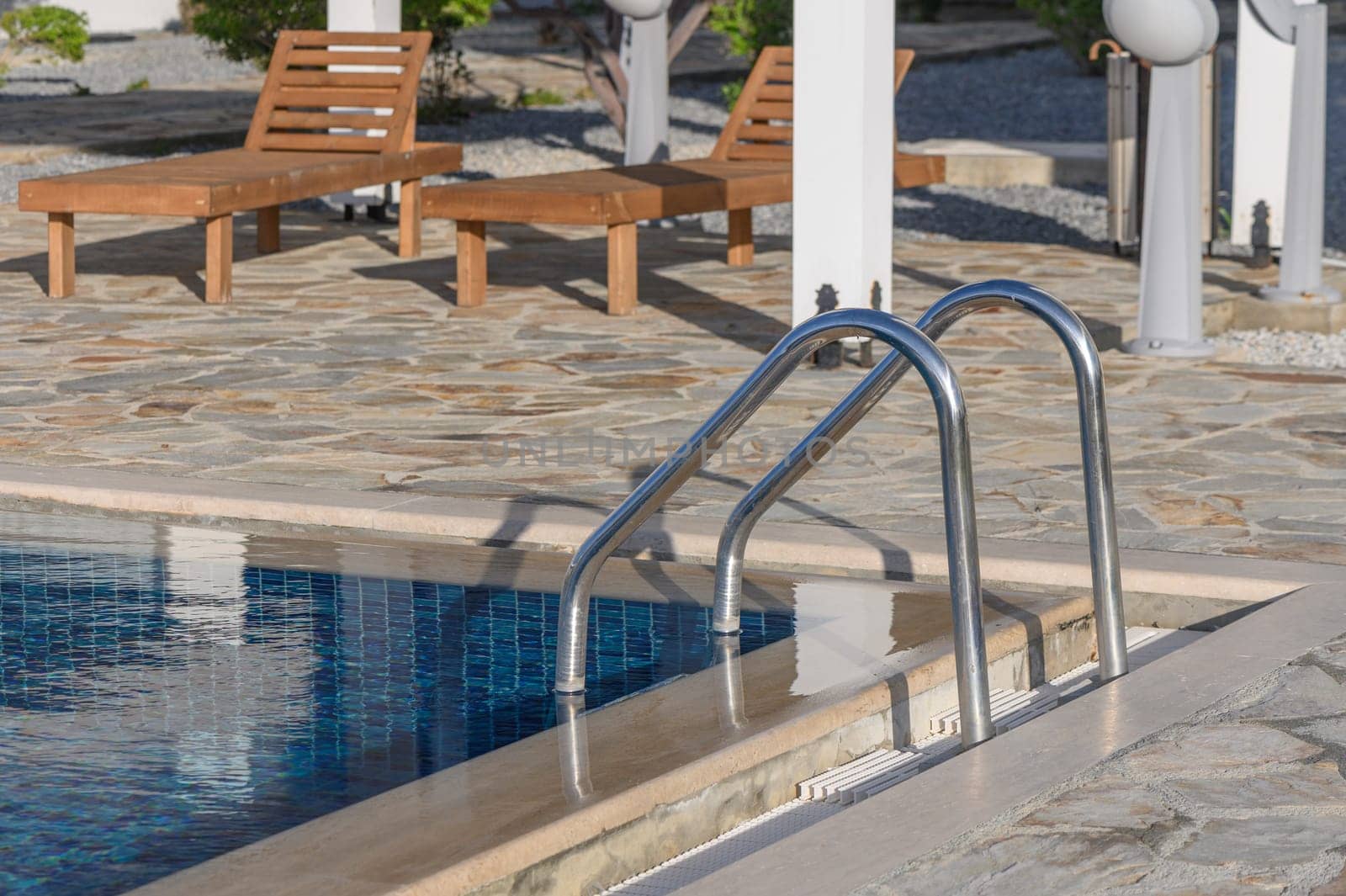 Clear turquoise water in the outdoor swimming pool and railings.