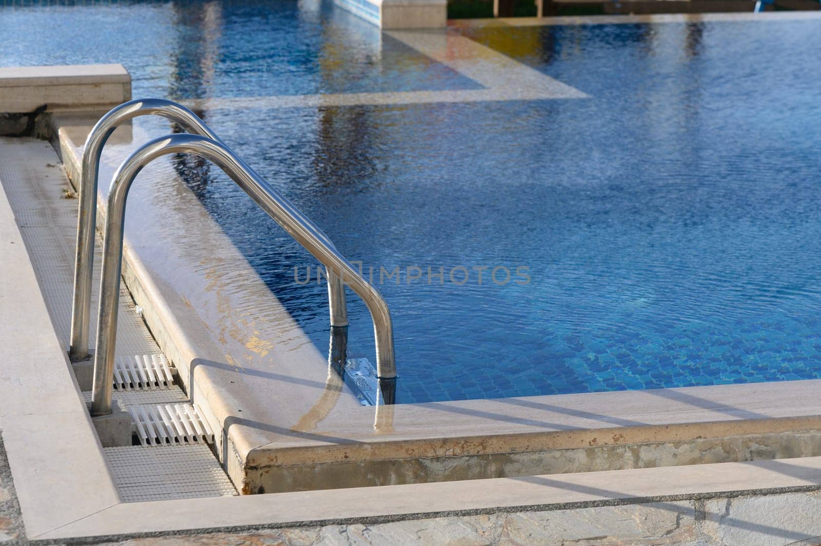 Grab bars ladder in the blue swimming pool 1