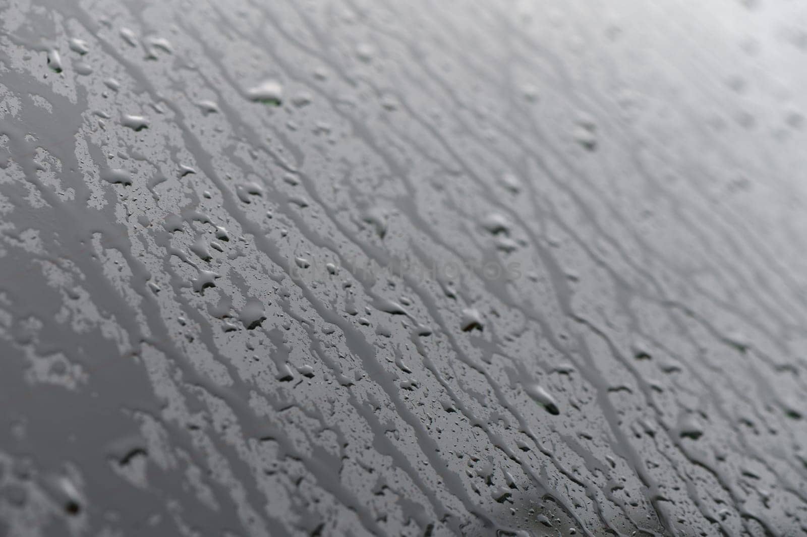 A small raindrop rests on the glass after rain.