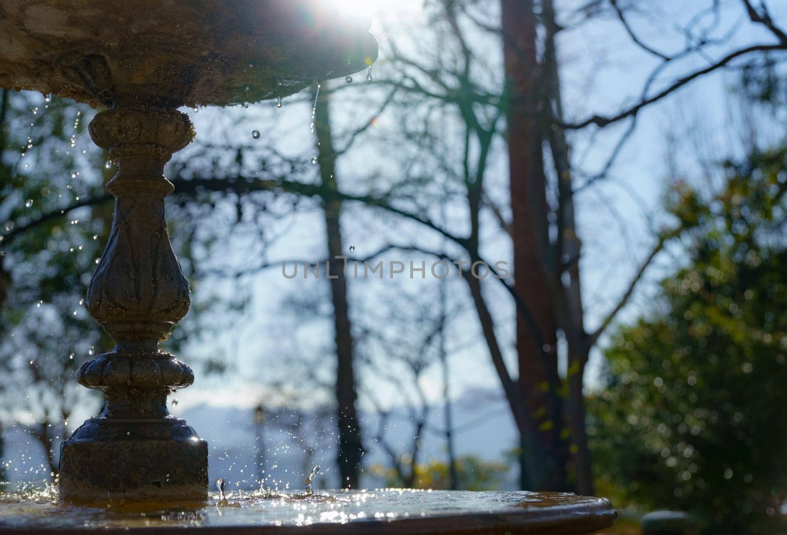 water from a public fountain splashing in the sunlight by joseantona