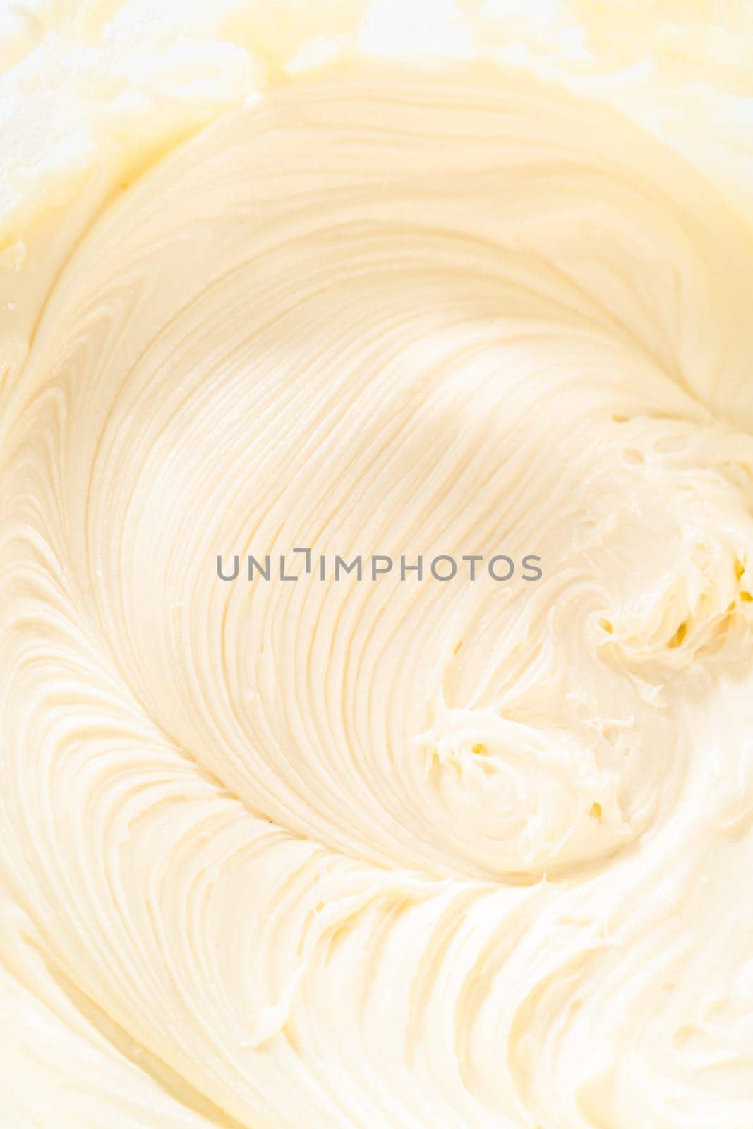 Skillfully combine ingredients using a hand mixer to prepare a rich, smooth cream cheese buttercream frosting, which is perfect for adorning the bundt cake.