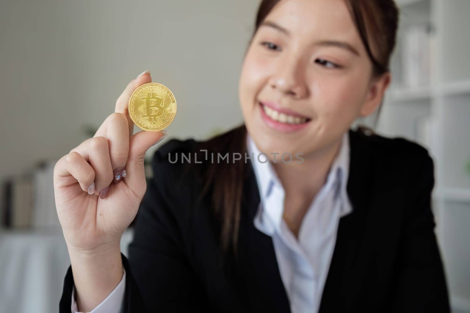 A successful business woman holds the cryptocurrency Bitcoin in her hands. Concept of trading and using digital currencies.