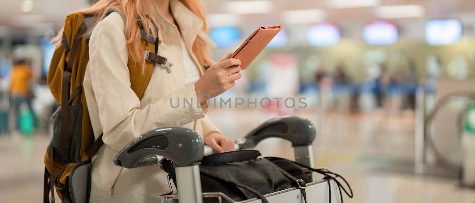 Hand of woman passenger holding passport with the flight in airport terminal by nateemee