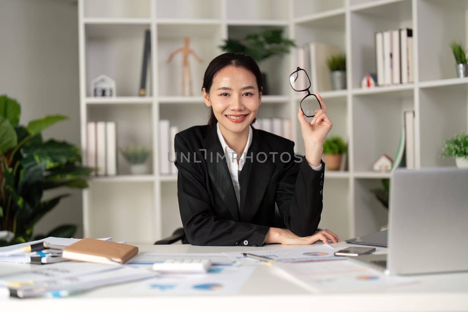 Young business woman asian or employee accounting bookkeeping documents checking financial data or marketing report working in office with laptop. Paperwork management.