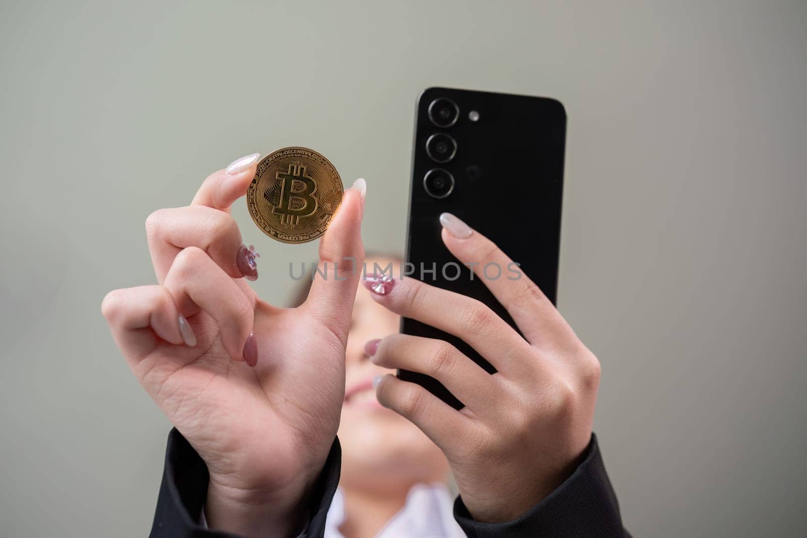 A successful business woman holds the cryptocurrency Bitcoin in her hands. Concept of trading and using digital currencies.