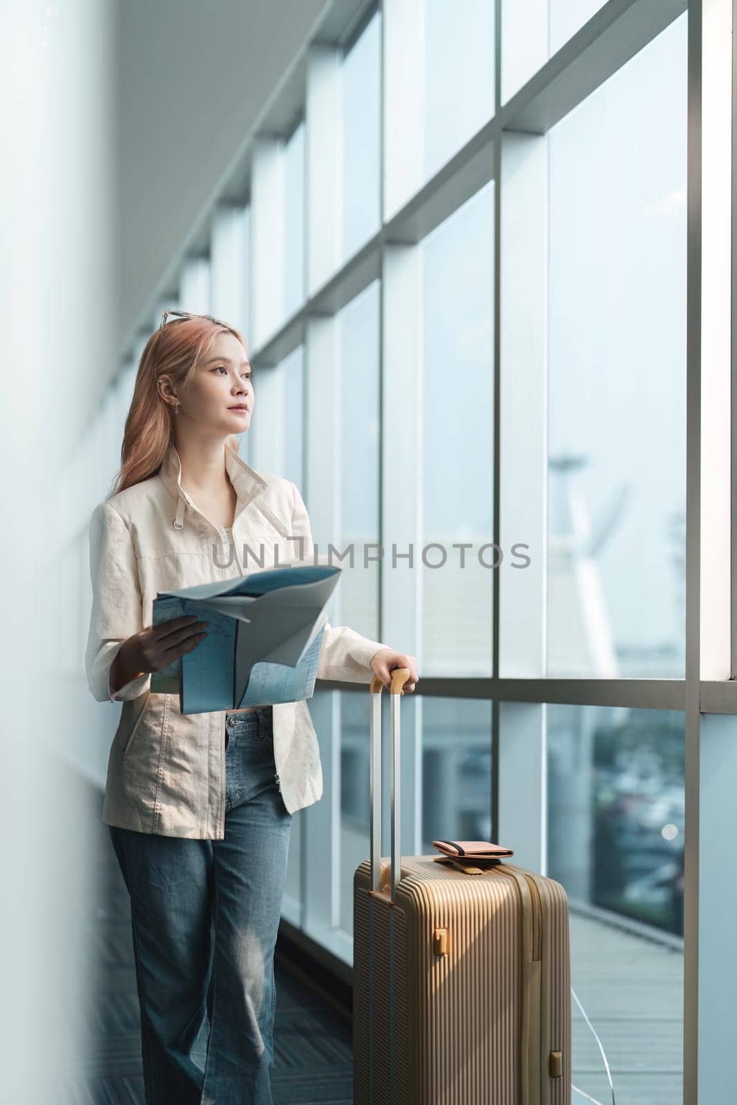 Happy young woman asian is stand in airport near suitcase and reading map by nateemee
