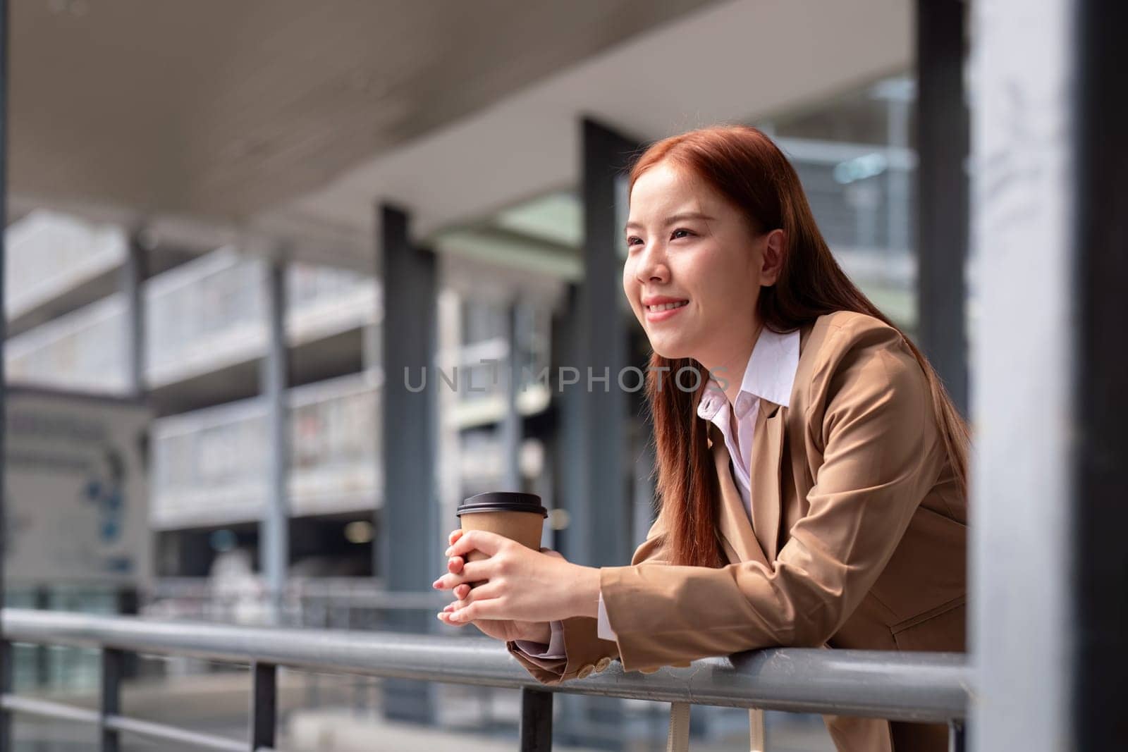 Beautiful successful business woman in walking on the street in business town with coffee. Preparation for the working day.