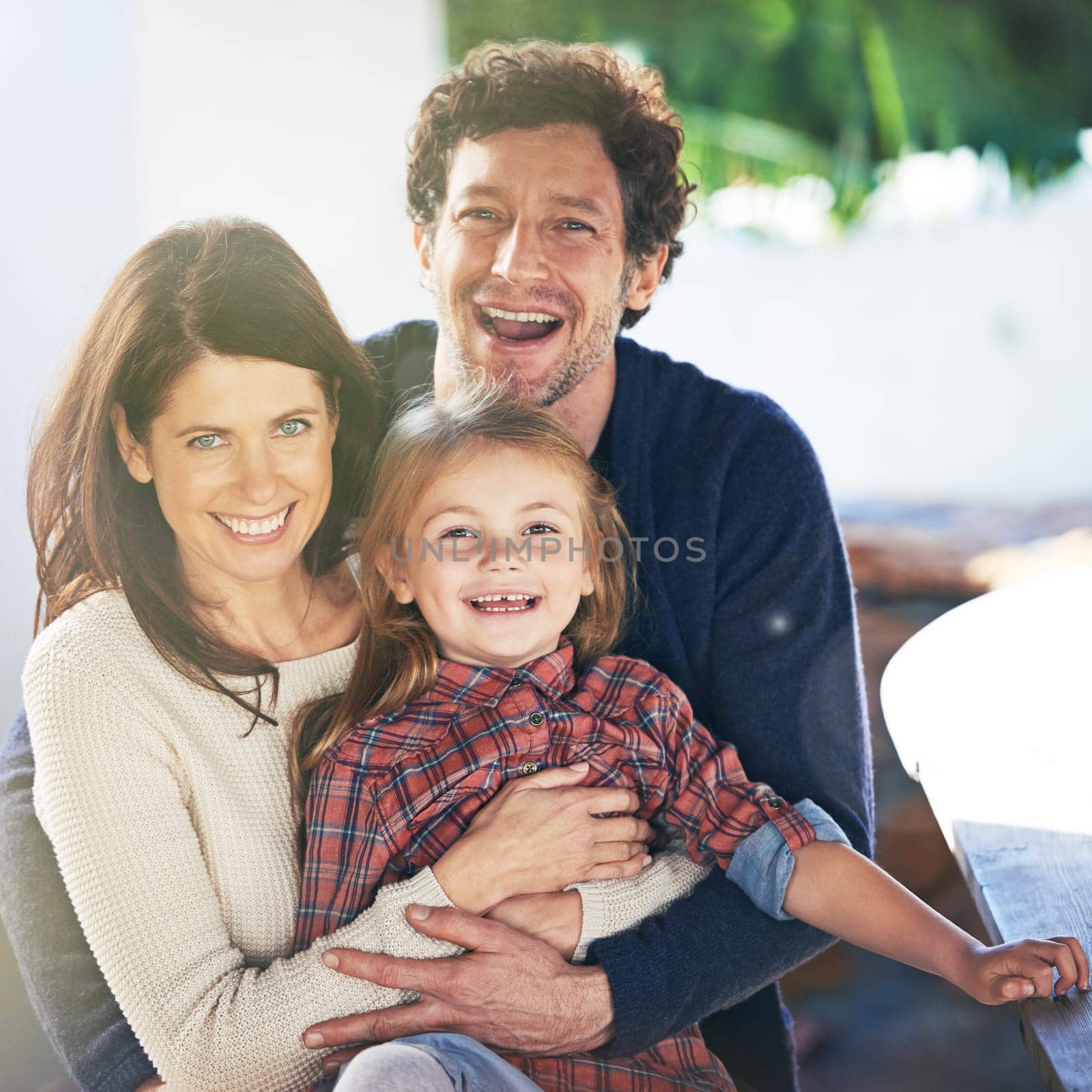 Happy family, portrait and smile in garden of home with embrace, relax and weekend break in summer. Parents, girl child and face with happiness in backyard of house with healthy relationship and love.