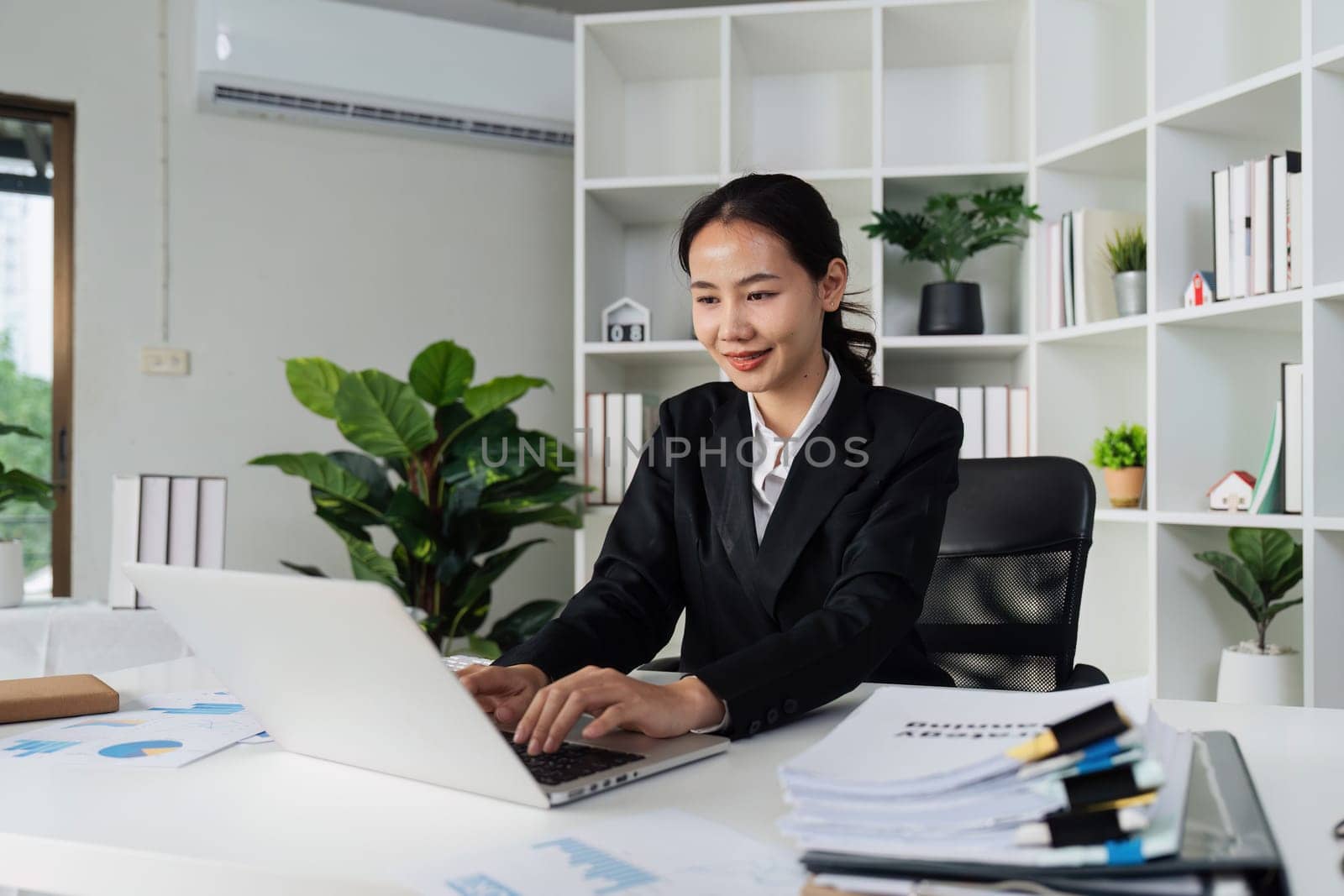 Businesswoman analyzing marketing strategy on laptop, typing work on laptop.