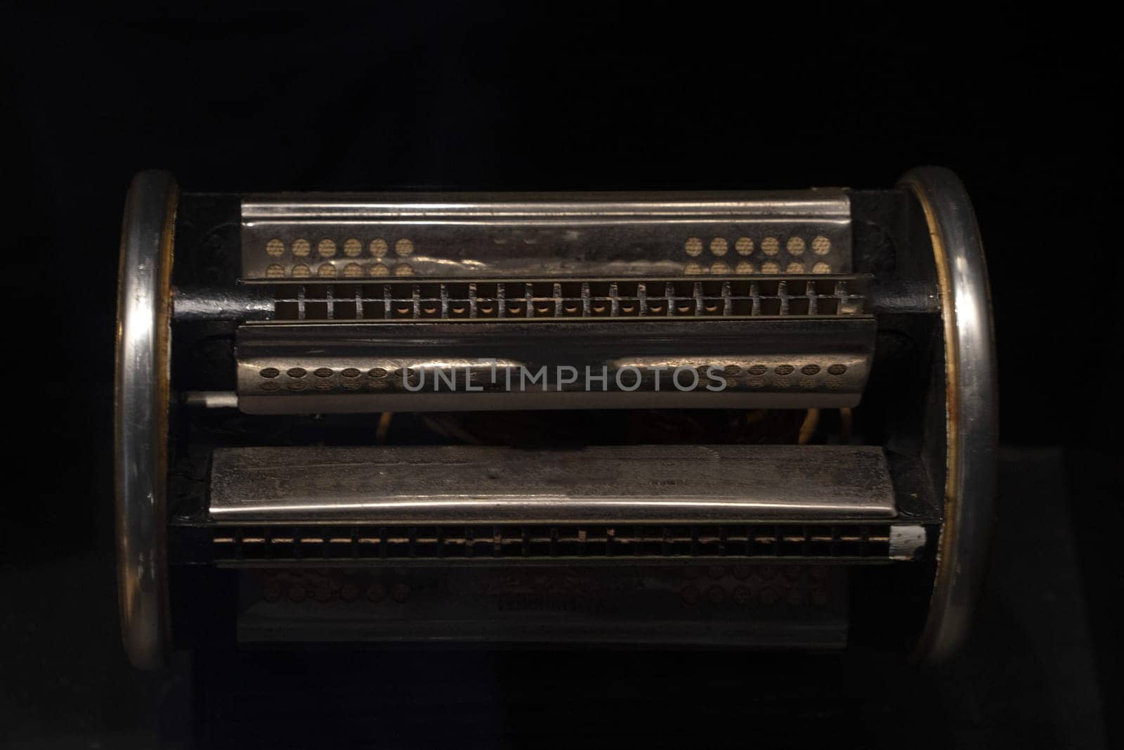 six sided harmonica isolated on black background