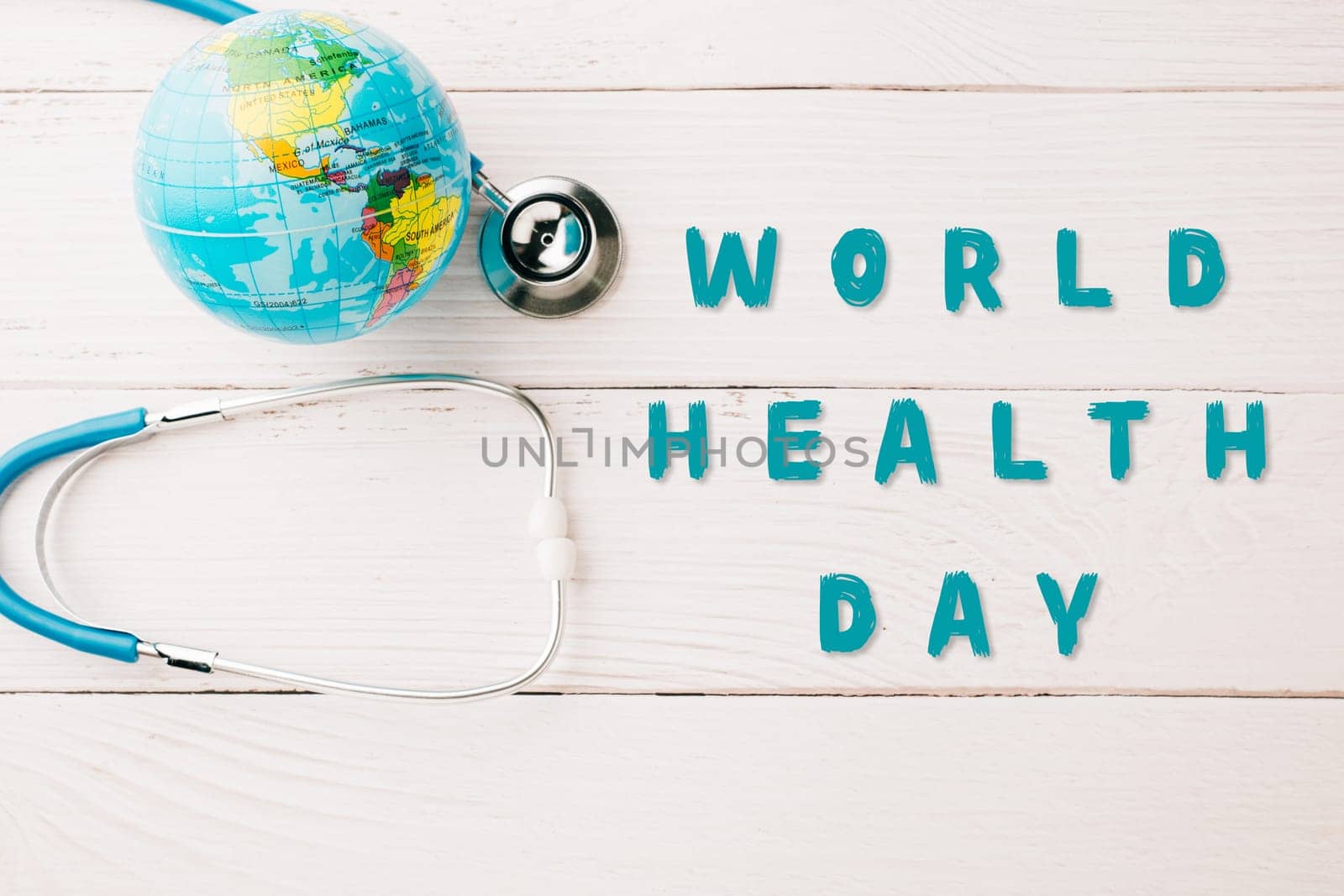 World Health Day. Blue doctor stethoscope and world globe isolated on wood background with copy space, Save world day, Green Earth, Healthcare and medical concept