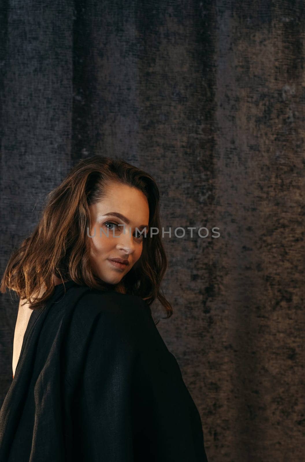 A woman wearing a black top striking a pose for a picture. Vertical frame.