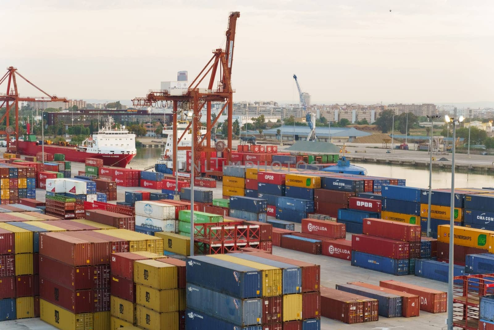 Seville, Spain - June 2, 2023: A massive cargo ship is securely anchored at the bustling port, ready for loading or unloading of goods.