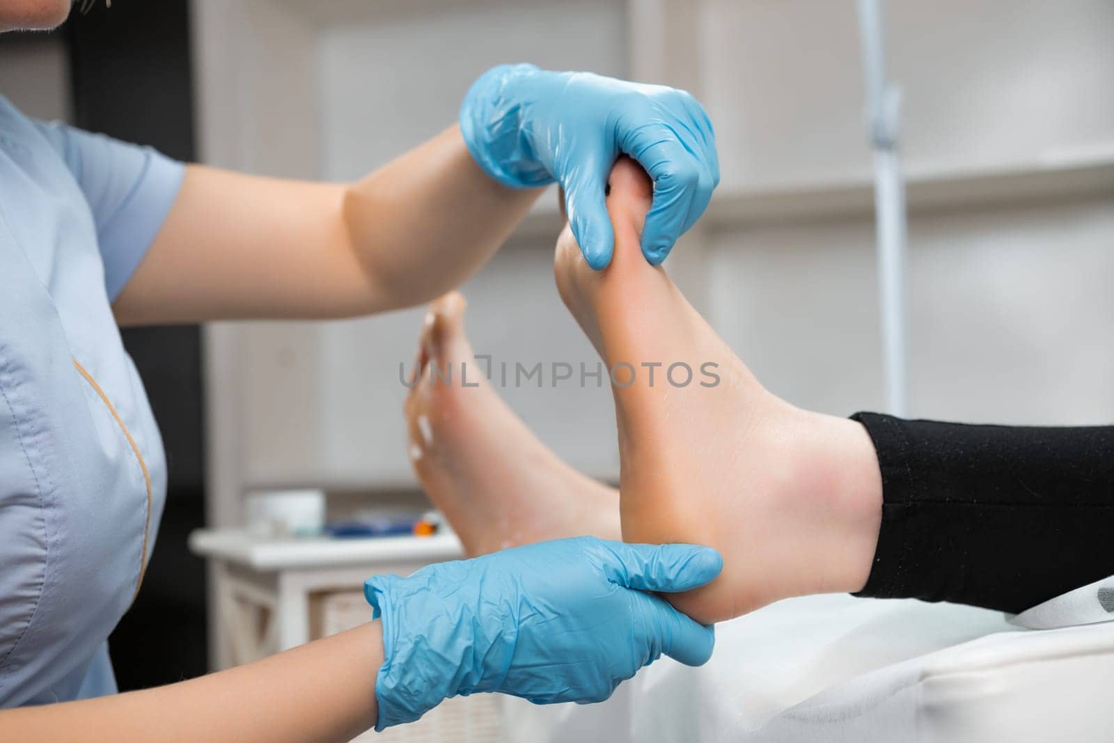 Professional foot massage to woman in beauty salon.