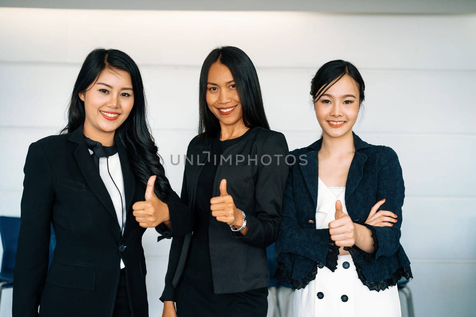 Young Asian businesswomen standing in office. uds by biancoblue