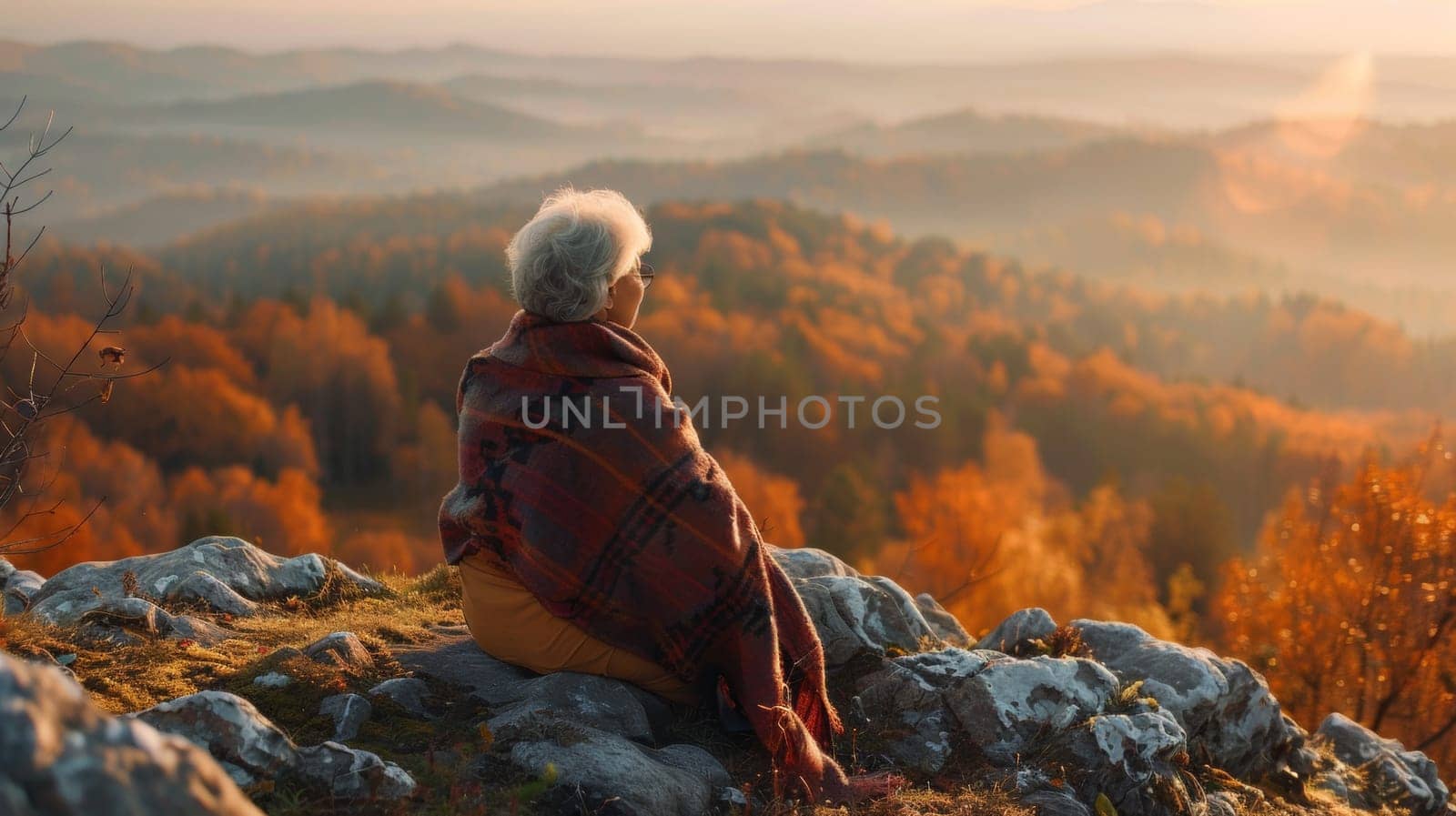 A woman sitting on a rock overlooking the mountains