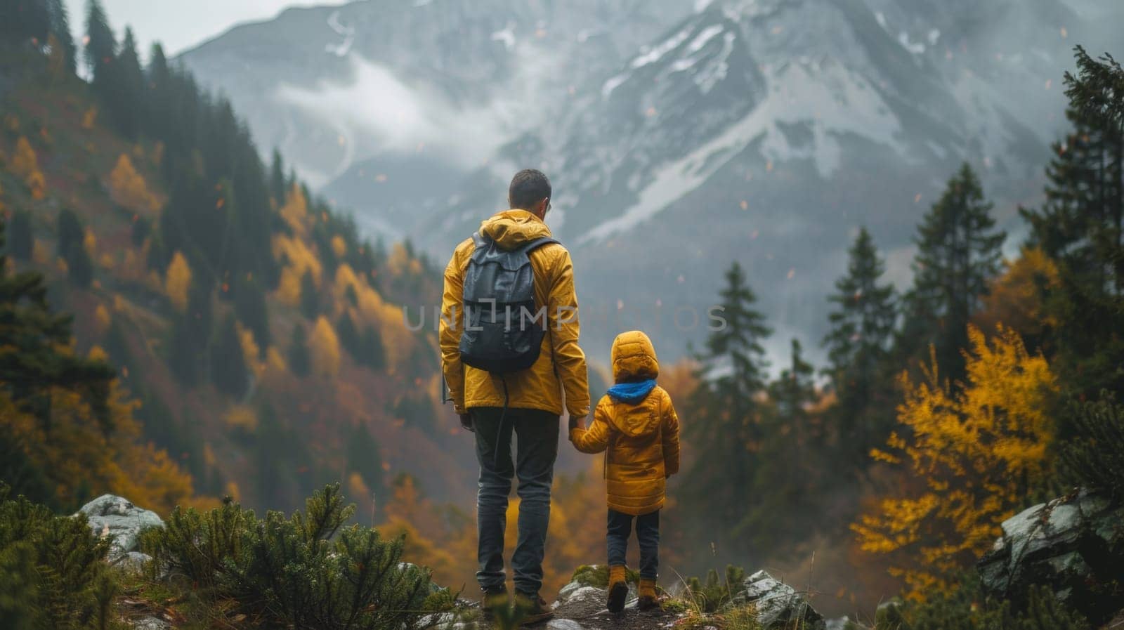 A man and child walking on a trail in the mountains