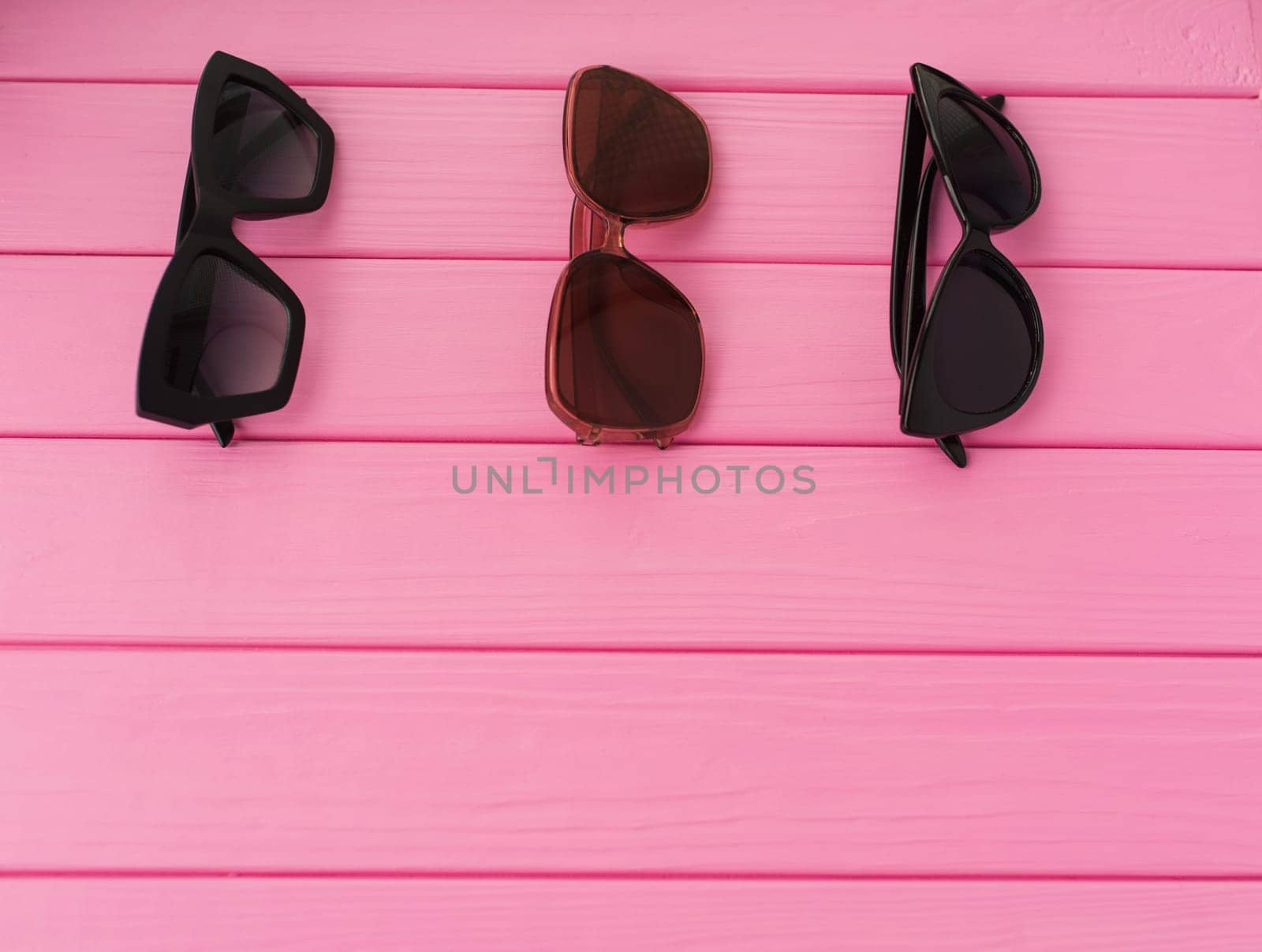 Summer abstract background mockup template free copy space for text pattern sample top view above on pink wooden board. blank empty area for inscription. Couple Stylish black sunglasses fashionable