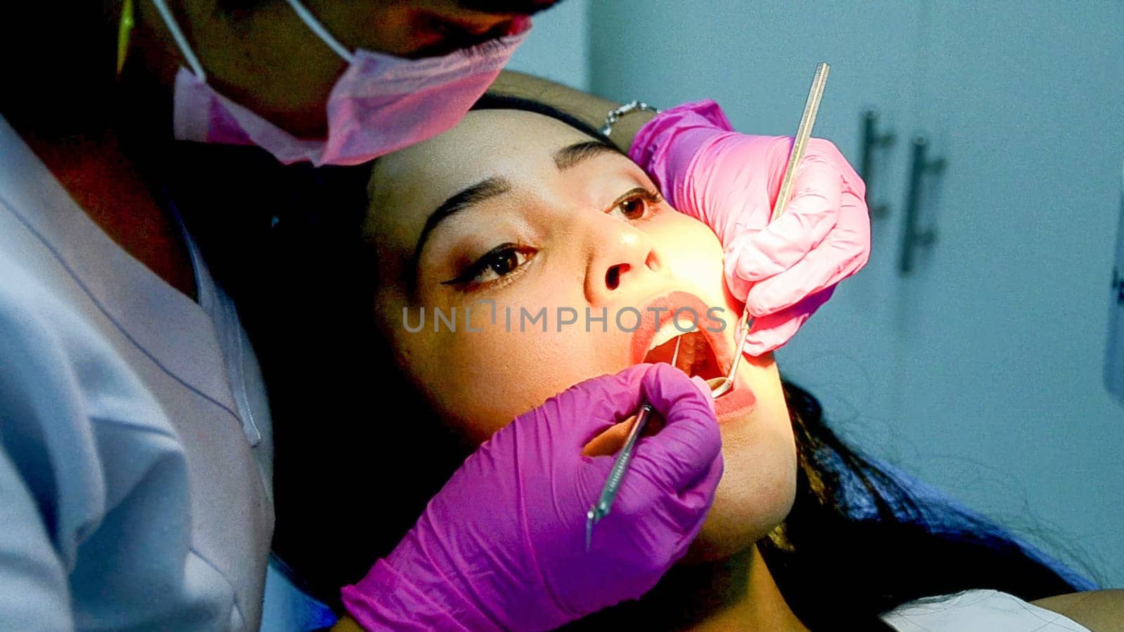 Dental patient receiving treatment from dentist by Peruphotoart