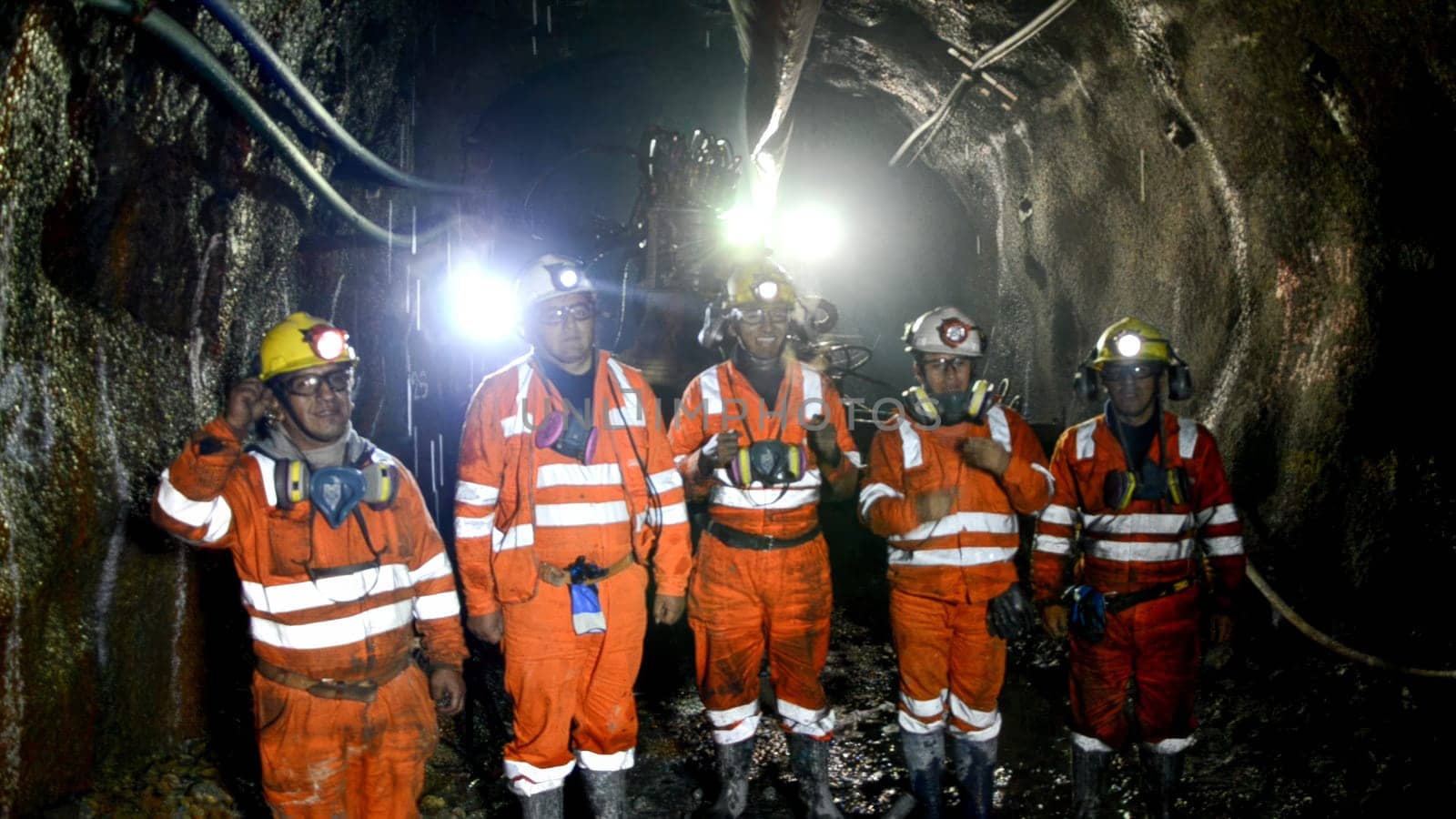 Cerro de Pasco, Peru - July 13th 2017 : Group of miners standing with safety gear inside a dark mine tunnel