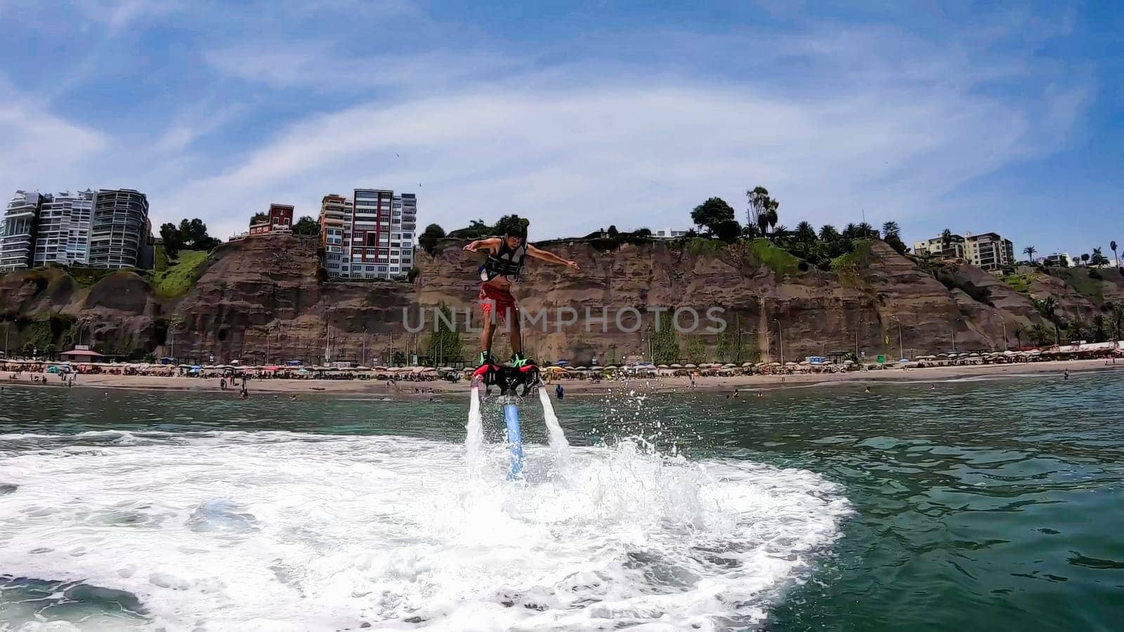 Thrilling display of flyboarding acrobatics with a coastal city backdrop