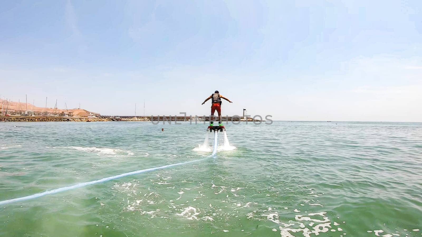 Man hovering above water on flyboard by Peruphotoart
