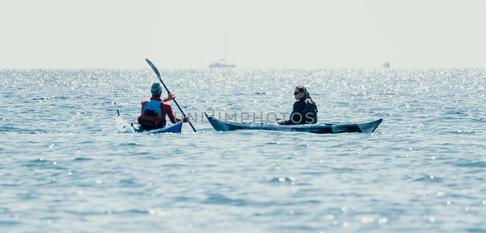 Man woman sea kayak. Happy free man and woman in kayak on ocean, paddling with wooden oar. Calm sea water and horizon in background. Active lifestyle at sea. Summer vacation. by panophotograph