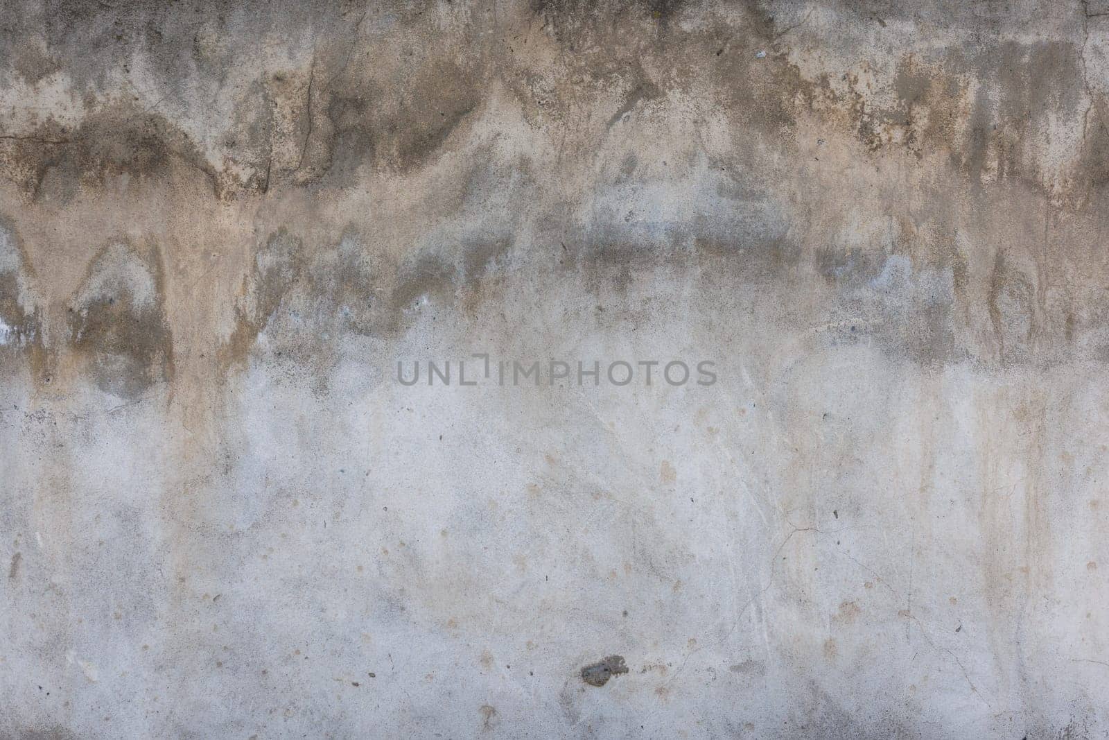 Close up of a grey concrete wall with numerous stains by z1b