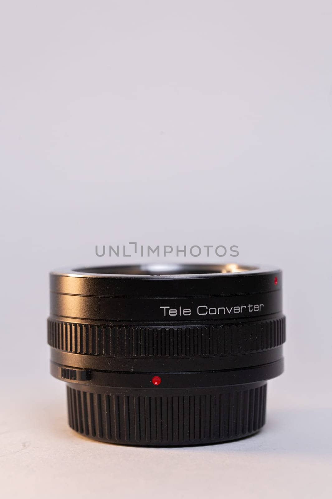 A black camera telephoto lens converter on a white background, perfect for photography enthusiasts and professionals.
