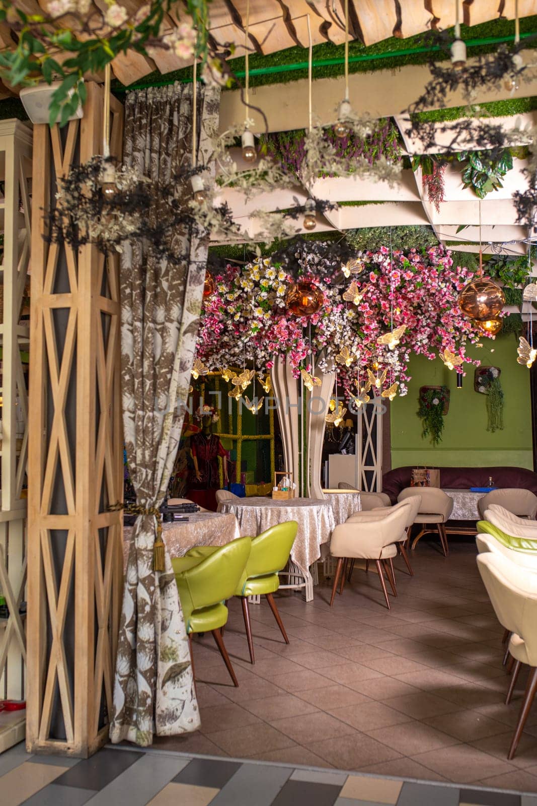 The image shows a beautifully decorated restaurant interior with a floral-adorned ceiling and elegant table settings.