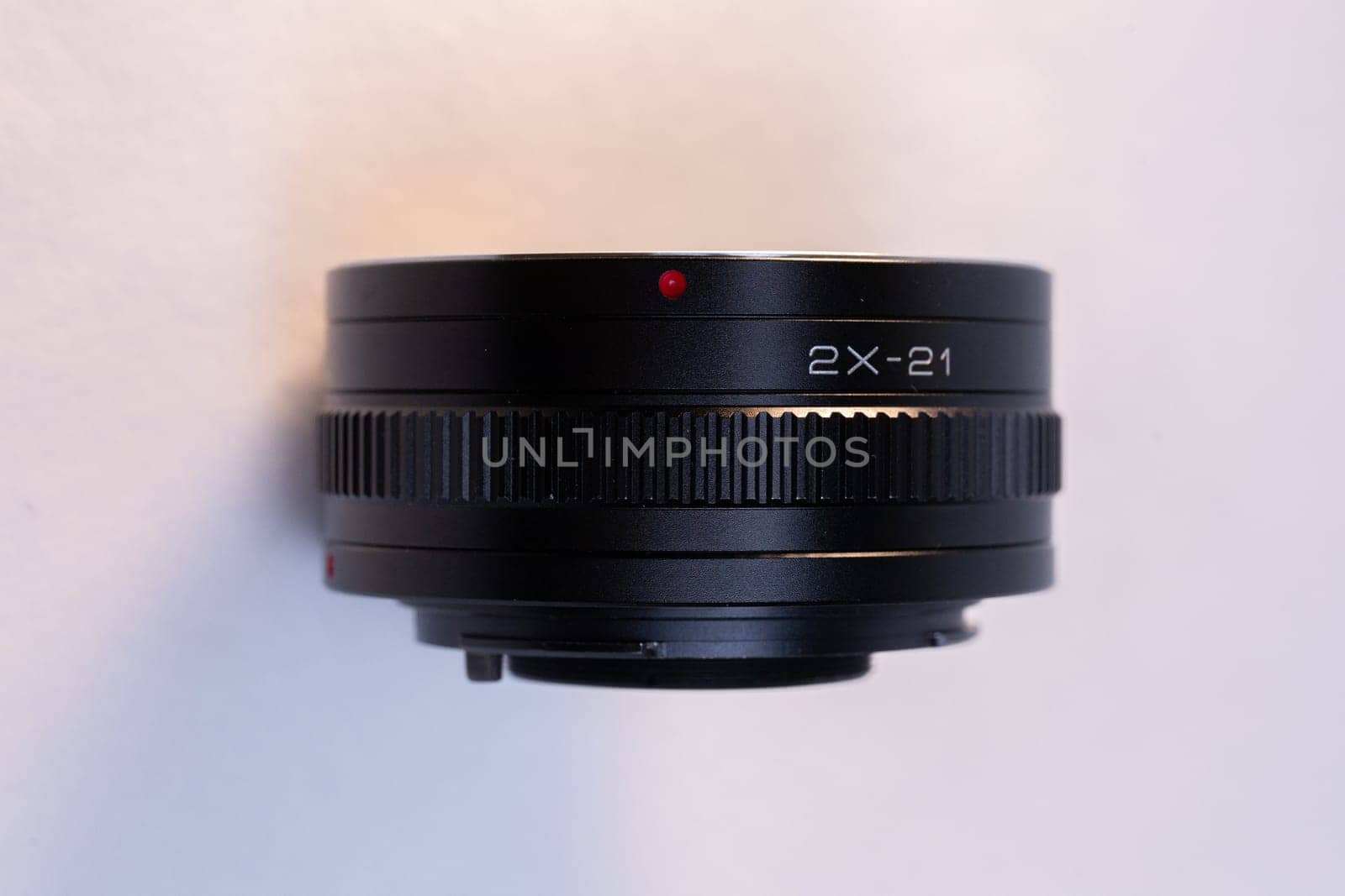 A black camera telephoto lens converter on a white background, perfect for photography enthusiasts and professionals.