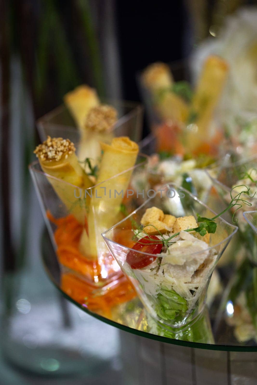 Close-up of variety of appetizers displayed on glass tray for catering event by Pukhovskiy
