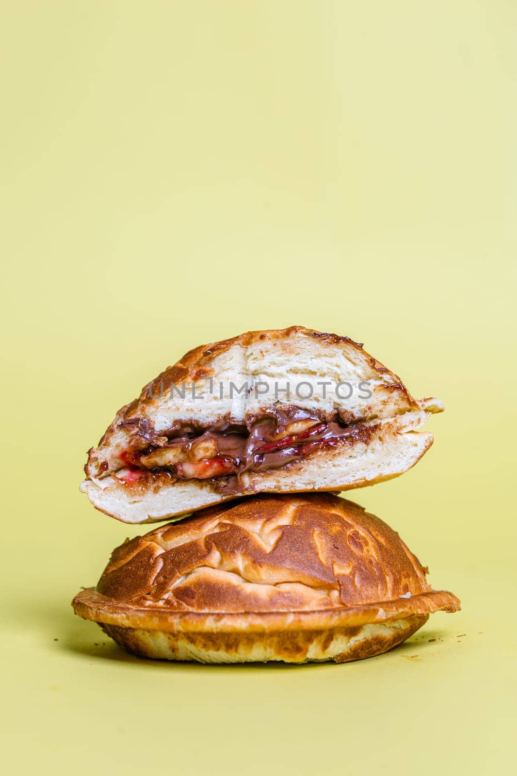 juicy burger cut with delicious filling on a yellow background by Pukhovskiy