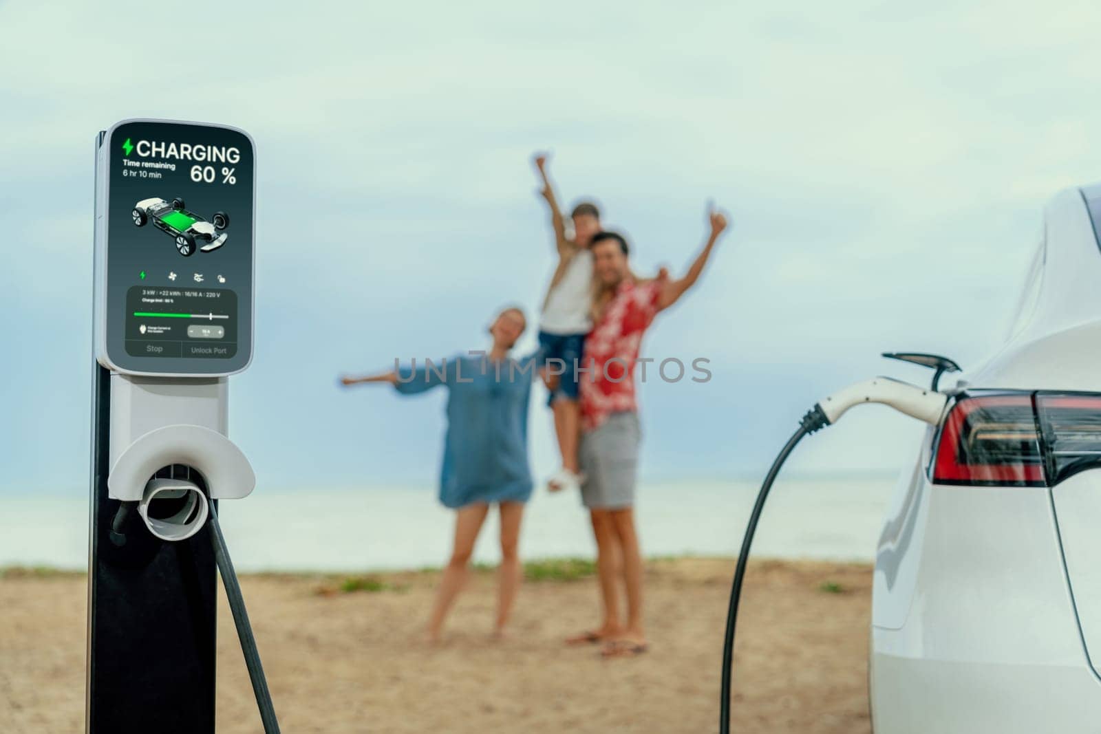 Alternative family vacation trip traveling by the beach with electric car recharging battery from EV charging station with blurred cheerful and happy family enjoying the seascape background. Perpetual