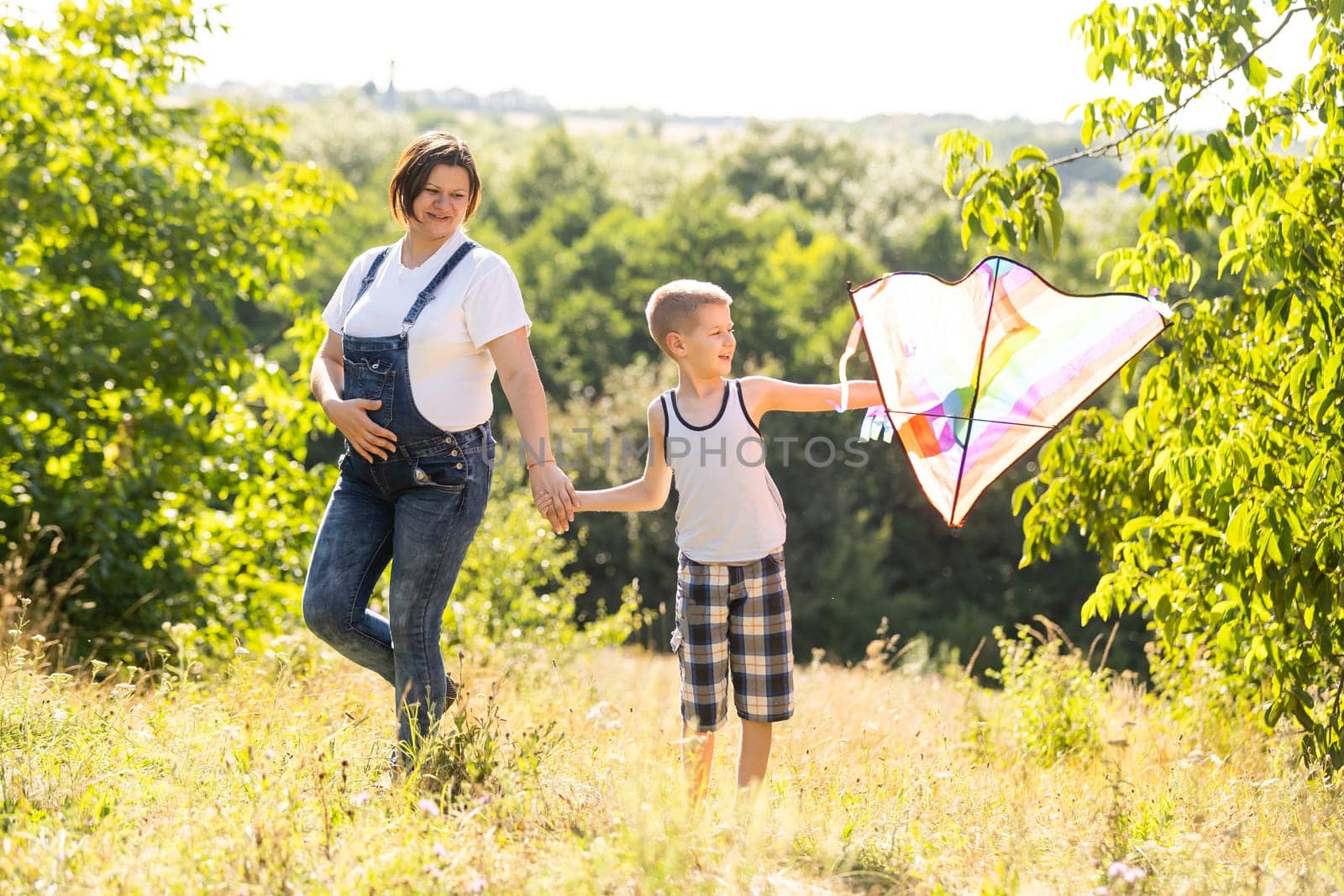 pregnant woman with her son playing a kite by Andelov13