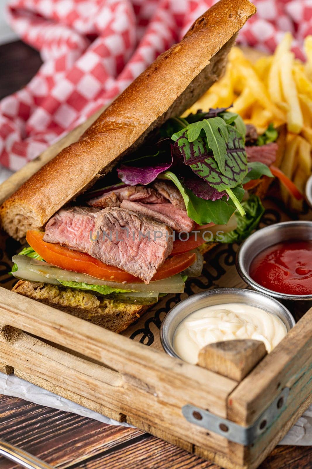 Grilled steak sandwich with french fries on a white porcelain plate