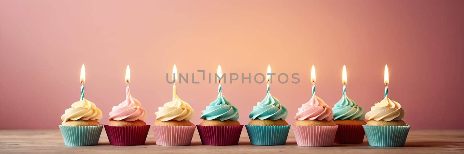 Colorful cupcakes with lit candles are displayed against a pink background, indicating an indoor celebration event marking of joy and celebrating. with free space by Matiunina