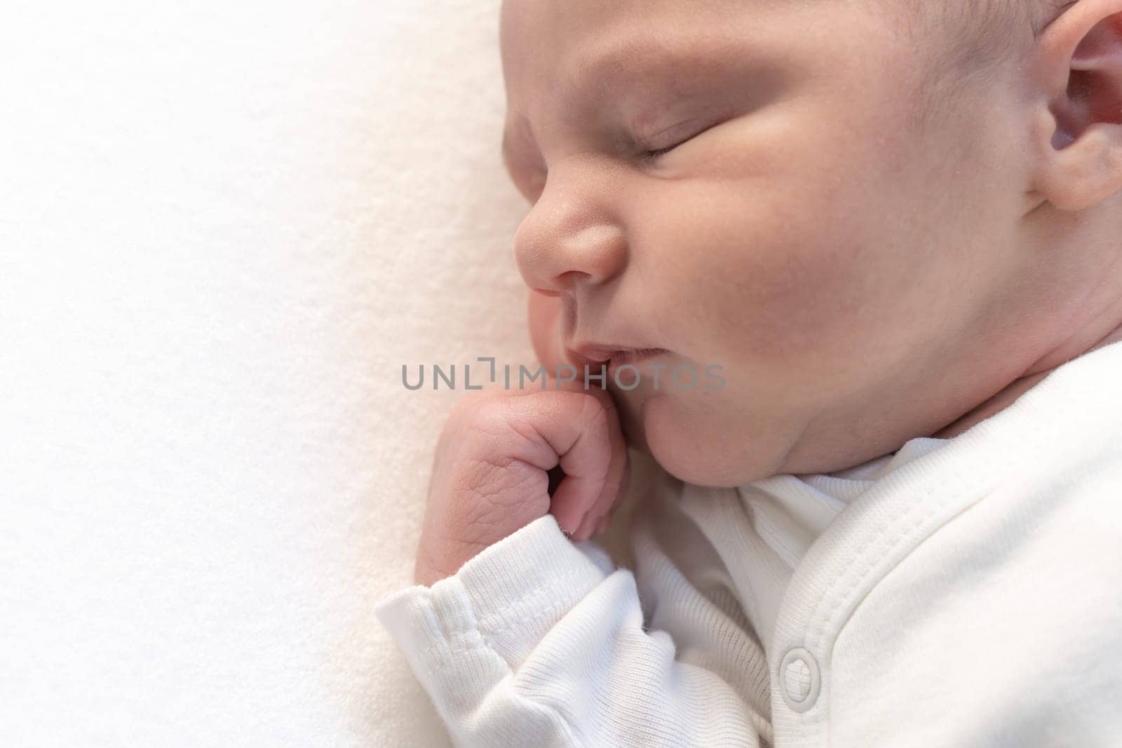 Sleeping newborn baby on white blanket banner. Beautiful portrait of little child close-up. by PaulCarr