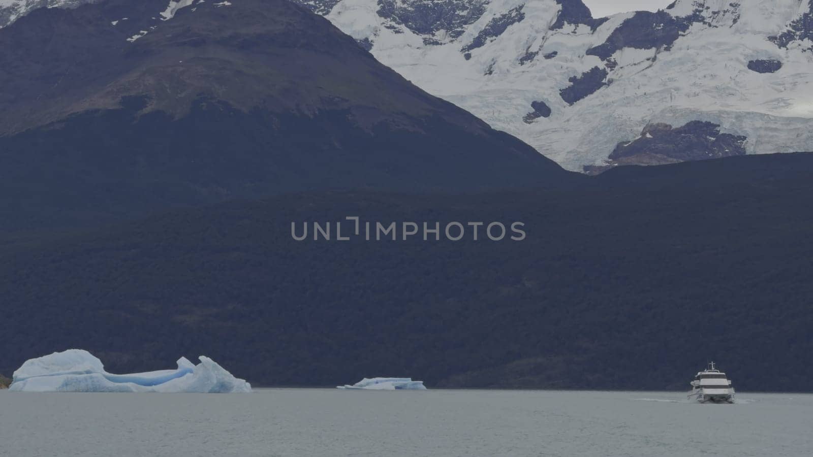 Slow Motion of Tourist Boat Amidst Massive Icebergs on Lake by FerradalFCG